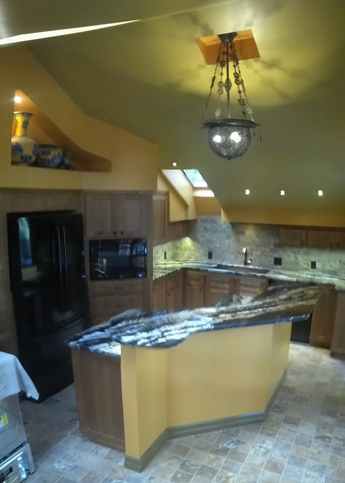 Finished kitchen remodel by Norton Construction with granite counters and stone backsplash